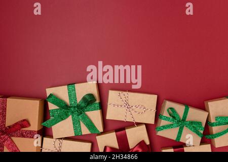 Cadeaux emballés sur fond rouge.Composition de la nouvelle année.Concept de lendemain de Noël. Banque D'Images