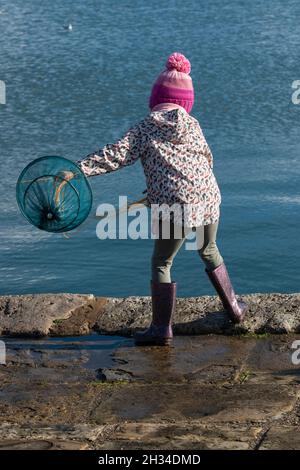 Une petite fille crabbing sur le quai de Langstone surplombant Emsworth Harbour, (près de Hayling Island) Havant, Hampshire, Angleterre, Royaume-Uni Banque D'Images