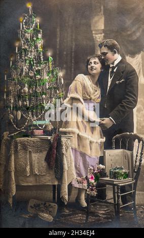 Homme et femme amoureux fêtés avec l'arbre de noël.Image vintage avec grain et flou de film d'origine Banque D'Images