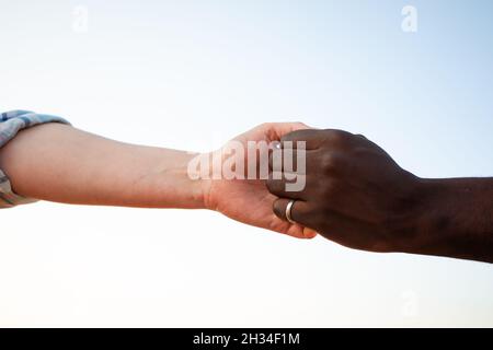 Concept de culture diversifiée. Mains d'homme noir et de femme blanche Banque D'Images