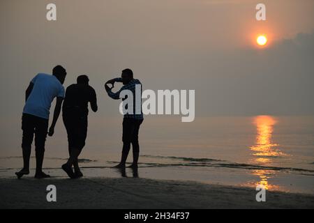 Patuakhali, Bangladesh.22 octobre 2021.Les touristes apprécient le soleil levant à la plage de Kuakata dans le district de Patuakhali du Bangladesh.Kuakata est l'un des rares endroits naturels qui offre une vue complète de la montée et le coucher du soleil sur la baie du Bengale.Une destination touristique populaire, il est à environ 320 kilomètres au sud de Dhaka, la capitale du Bangladesh.(Photo de Piyas Biswas/SOPA Images/Sipa USA) crédit: SIPA USA/Alay Live News Banque D'Images