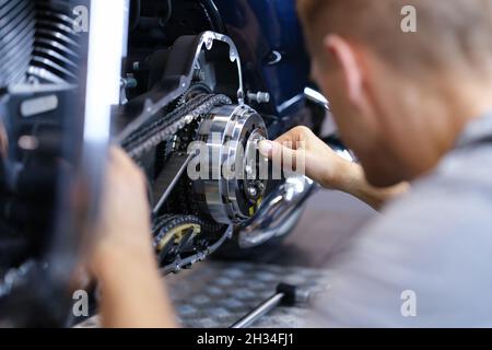 Un mécanicien répare le moteur de la moto à la fermeture de l'atelier Banque D'Images