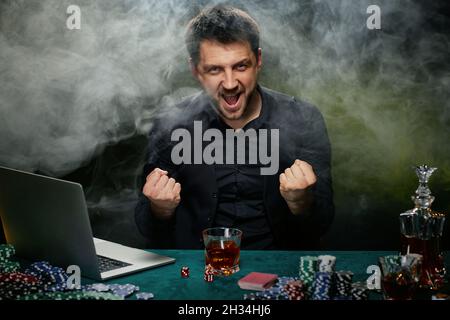 Joueur de casino barbu en ligne homme célébrant la victoire Banque D'Images