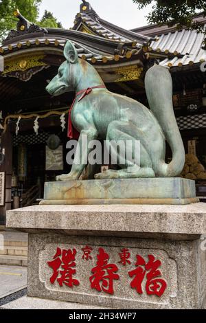 Une imposante statue en bronze de Inari Kitsune ou déesse du renard, garde le temple Toyokawa Inari Betsuin à Asakusa, Tokyo, Japon.Le temple bouddhiste fait partie de la secte Zen Soto et consacre la divinité Toyokawa Dakinishinten, mais aussi connue pour les milliers de statues de renards. Banque D'Images