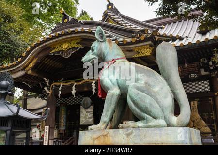 Une imposante statue en bronze de Inari Kitsune ou déesse du renard, garde le temple Toyokawa Inari Betsuin à Asakusa, Tokyo, Japon.Le temple bouddhiste fait partie de la secte Zen Soto et consacre la divinité Toyokawa Dakinishinten, mais aussi connue pour les milliers de statues de renards. Banque D'Images