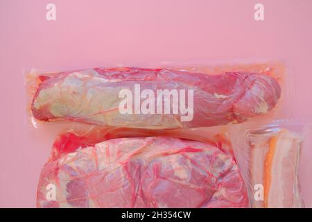 Viande de porc.morceaux de porc frais .Aliments protéinés.passer l'aspirateur sur une viande sur fond rose.produits de viande. Banque D'Images