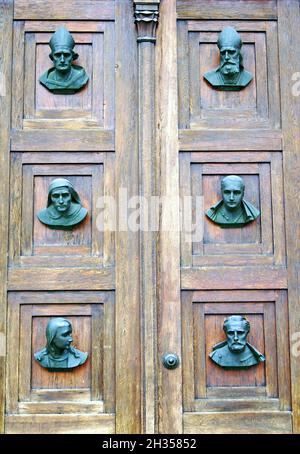 La porte principale de la basilique S. Marriacki, connue sous le nom de basilique Sainte-Marie, est ornée de sculptures représentant des chefs d'apôtres, des saints polonais et des prophètes à Cracovie, en Pologne.L'église, réédifiée au XIVe siècle, les portes ont été achevées en 1929 avec les sculptures créées par Karol Hukan. Banque D'Images