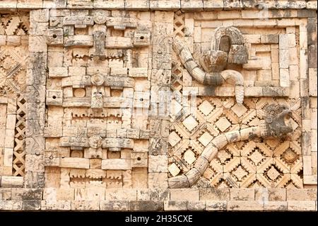 Bas-relief en pierre sculptée maya de masques Chaac et serpent à plumes, Nunnery Quadrangle, Uxmal, Yucatan, Mexique Banque D'Images