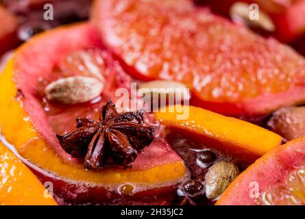 Gros plan de la boisson de Noël traditionnelle chaude à la vapeur au vin rouge épicé chaud et chaud, gluhwein bouillant avec des pommes et des agrumes.Fête de Noël. Banque D'Images