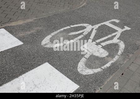 Le symbole d'un vélo blanc a été peint sur la piste cyclable. Banque D'Images