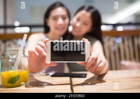 Deux meilleurs amis prenant des selfies sur un téléphone mobile Banque D'Images