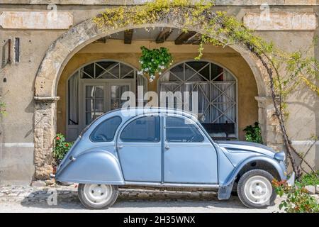 2 CV légendaires garés devant les arcades de la place Royale à Labastide-d'Armagnac, France Banque D'Images