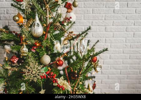 Magnifique arbre de Noël décoré sur fond de mur en brique blanche.Copier l'espace. Banque D'Images