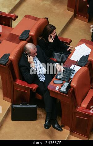 Bucarest, Roumanie, 4 mars 2009 : les députés parlent au téléphone à l'intérieur du Parlement roumain, au cours d'une session parlementaire. Banque D'Images