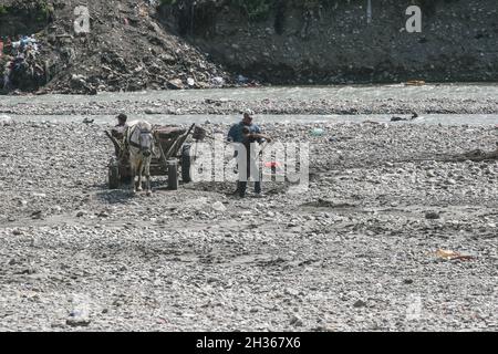 Tarlungeni, Brasov, Roumanie, 22 août 2009 : les hommes sont en charge d'un panier avec du gravier de la rivière. Banque D'Images