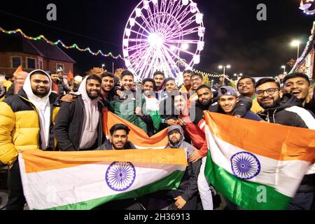 Le voyant Diwali s'allume chaque année à Leicester.Des milliers de personnes ont essaié dans le Golden Mile la région de Leicester le long de la route Belgrave pour célébrer le début du festival.Le festival est l'un des plus grands festivals de Diwali en Europe.Un grand groupe de jeunes hommes avec des drapeaux pose devant la roue du Festival de lumière sur le Golden Mile. Banque D'Images