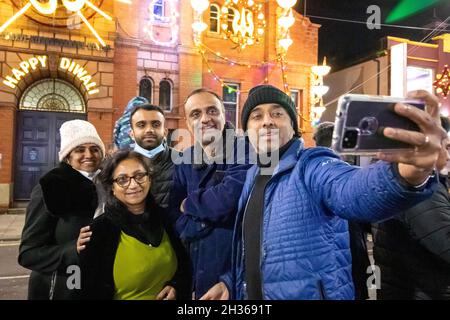 Le voyant Diwali s'allume chaque année à Leicester.Des milliers de personnes ont essaié dans le Golden Mile la région de Leicester le long de la route Belgrave pour célébrer le début du festival.Le festival est l'un des plus grands festivals de Diwali en Europe.Une famille prend un portrait de selfie à l'extérieur du Centre Belgrave. Banque D'Images