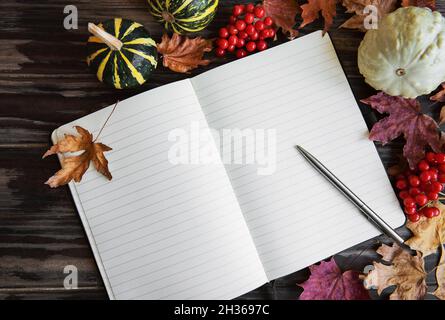 Composition d'automne. Citrouilles et feuilles avec bloc-notes sur fond en bois. Concept d'automne. Arrière-plan de l'automne. Flat lay, vue de dessus, espace de copie Banque D'Images