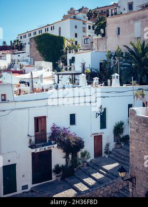 IBIZA, ESPAGNE - 14 octobre 2020 : les escaliers en pierre à côté des vieux bâtiments grungy blancs d'Ibiza avec balcons par temps ensoleillé Banque D'Images