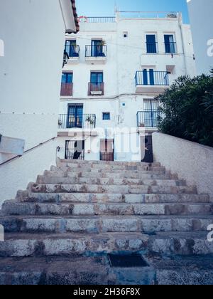 IBIZA, ESPAGNE - 14 octobre 2020 : un plan vertical d'escaliers en pierre menant à un vieux bâtiment blanc avec balcons par temps ensoleillé Banque D'Images