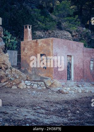 IBIZA, ESPAGNE - 14 octobre 2020 : vue verticale d'un vieux bâtiment en pierre aux intempéries et à la trappe en bois d'Ibiza Banque D'Images
