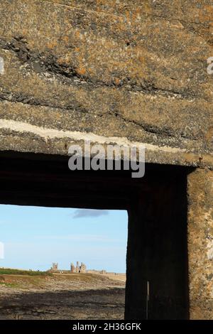 Le château de Dunstanburgh, datant du XIVe siècle, au nord de Craster, à Northumberland, au Royaume-Uni, vu du port de Craster. Banque D'Images