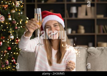 Joyeux Noël fille dans le chapeau de Santa toasting de vin Banque D'Images