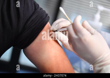 Changsha, province chinoise du Hunan.26 octobre 2021.Un résident reçoit une dose de rappel du vaccin COVID-19 dans un centre de services communautaires du district de Tianxin, à Changsha, dans la province centrale de Hunan, en Chine, le 26 octobre 2021.Credit: Chen Zeguo/Xinhua/Alay Live News Banque D'Images