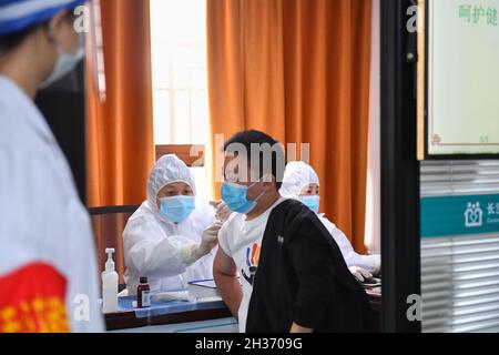 Changsha, province chinoise du Hunan.26 octobre 2021.Un résident reçoit une dose de rappel du vaccin COVID-19 dans un centre de services communautaires du district de Tianxin, à Changsha, dans la province centrale de Hunan, en Chine, le 26 octobre 2021.Credit: Chen Zeguo/Xinhua/Alay Live News Banque D'Images