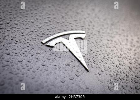 Logo de marque Tesla sur une voiture grise avec raindrops gros plan.Badge argenté avec gouttes d'eau.Tesla Motors est une entreprise américaine qui fabrique des voitures électriques modernes.Varsovie, Pologne - 23 octobre 2021 Banque D'Images