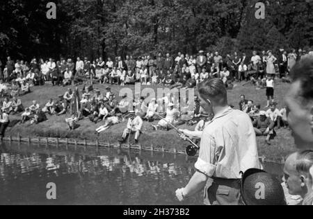 Junger erfahrener pêcheur Profi angelt une einem Steg, Deutschland, 1930 er Jahre. Jeune professionnel de pêche pêcheur sur la rive d'un lac, l'Allemagne des années 1930. Banque D'Images