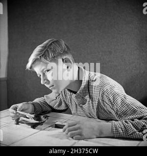 Série: Ein neugieriger Junge probiert seine erste Zigarette, Deutschland 1940er Jahre.Un curieux garçon essayant sa première cigarette, Allemagne des années 1940. Banque D'Images