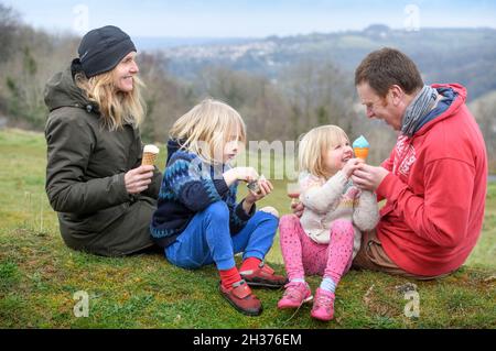 Une famille avec des glaces de Winstone Ice Cream sur Rodborough Common à Stroud, Gloucestershire. Banque D'Images