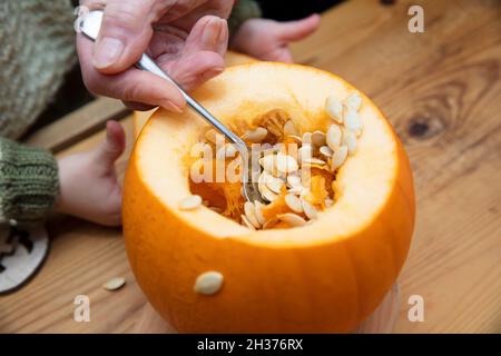 Citrouille d'Halloween orange sculptée dans une décoration de lanterne par une grand-mère et un enfant Banque D'Images