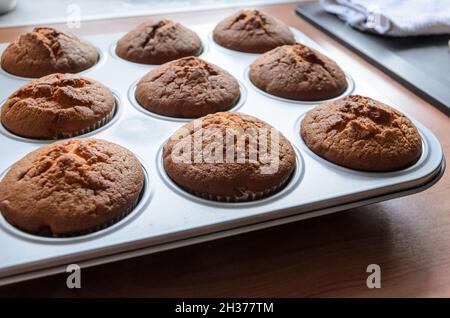 Muffins frais faits maison dans une plaque de cuisson en métal dans la cuisine, vue de dessus directement Banque D'Images