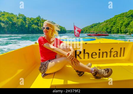 Femme sur le bateau sur la cascade suisse Rhin Falls en Suisse.La cascade la plus puissante et la plus grande d'Europe, dans les cantons de Schaffhausen et Banque D'Images