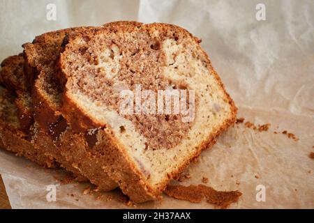 Concept de plats maison savoureux.Pain de pâtisserie frais sur du papier de cuisson gris en tranches.Gâteau de Noël ou délicieux dessert cuit au four.Photo de haute qualité Banque D'Images