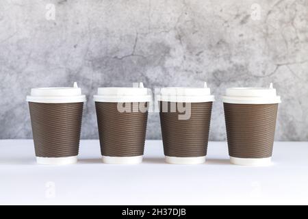 Quatre tasses à café en papier ondulé jetables à emporter avec bouchons en gros plan Banque D'Images