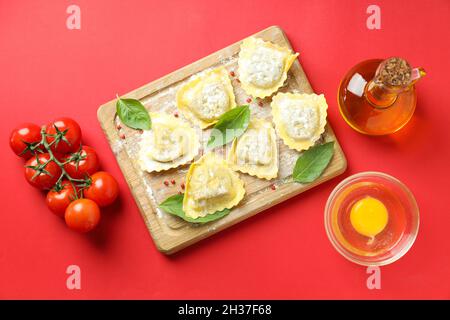 Concept de cuisson des raviolis sur fond rouge Banque D'Images