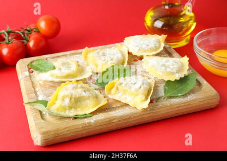 Concept de cuisson des raviolis sur fond rouge Banque D'Images