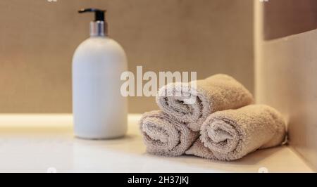 Décoration intérieure de la salle de bains.Nettoyez les rouleaux d'essuie-mains, le distributeur de savon et le lavabo blanc sur une table, une bannière Banque D'Images