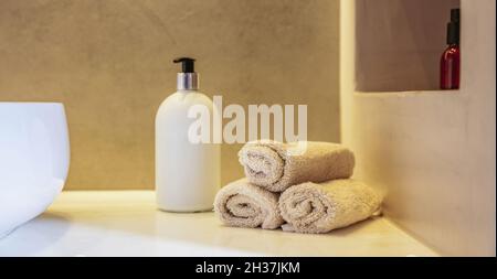 Décoration intérieure de la salle de bains.Nettoyez les rouleaux d'essuie-mains, le distributeur de savon et le lavabo blanc sur une table, une bannière Banque D'Images