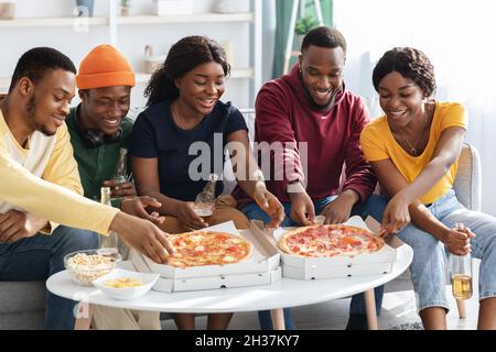Bonne vie de la génération du millénaire noir en savourant une pizza à la maison Banque D'Images