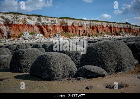 Boulettes ou pierres disposées en lignes droites recouvertes de moules et de barnacles à Hunstanton Beach, Norfolk Banque D'Images