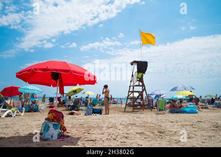 VALENCE, ESPAGNE - 22 septembre 2021 : Communauté Valencienne, Espagne - août 2021.Scène d'été à la plage.Touristes et parasols autour de poste de Lifeguard avec Banque D'Images