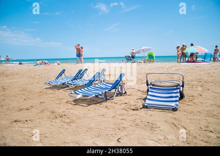 ALCOSSEBRE, ESPAGNE - 22 septembre 2021 : Communauté Valencienne, Espagne - août 2021. Vider les chaises longues en plastique blanc et bleu sur la plage. Vacances à la plage avec Banque D'Images