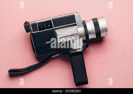 Appareil photo vintage super 8 sur fond rose.Concept de vlogging.Appareil photo rétro, blogueur féminin. Banque D'Images