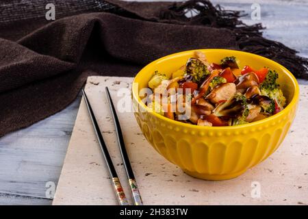 poulet yakissoba dans un bol jaune. Banque D'Images