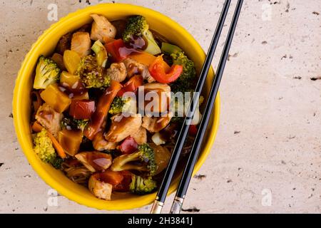 poulet yakissoba dans un bol jaune. Banque D'Images