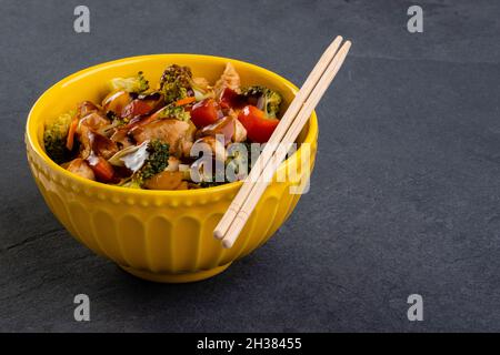 poulet yakissoba dans un bol jaune. Banque D'Images